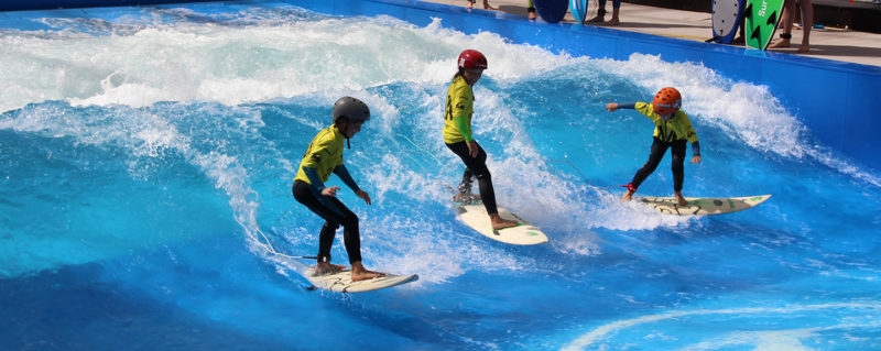 Des enfants sur MY SURF City WAVE, nouvelle attraction et vague artificielle au parc aquatique WAVE ISLAND, à Monteux, près d'Avignon, en Provence